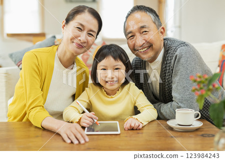 祖父母看著孫子在平板電腦上學習 祖父母看著孫子在平板電腦上學習 123984243
