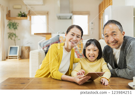 Grandparents watching their grandchildren studying on a tablet 123984251