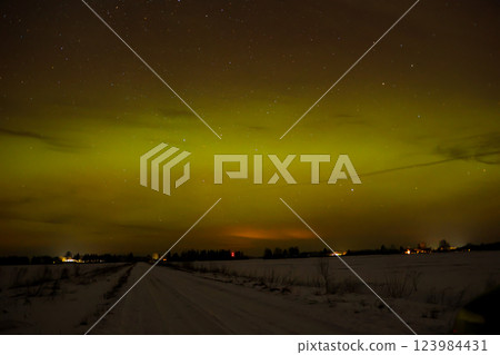 Winter northen lights on field near the road 123984431