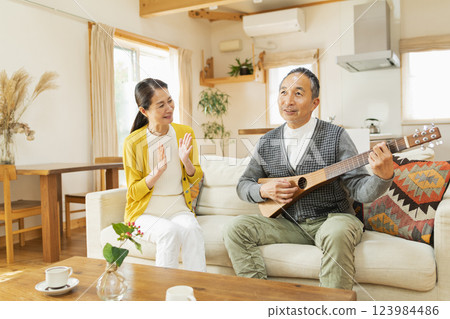 Senior man playing musical instrument at home 123984486
