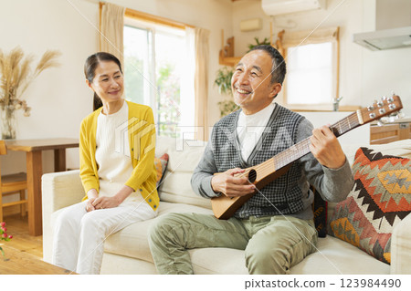 Senior man playing musical instrument at home 123984490