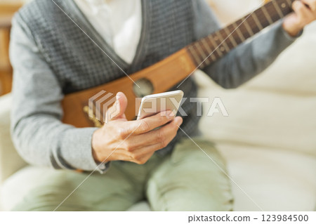 在家演奏樂器的老人 在家演奏樂器的老人 123984500
