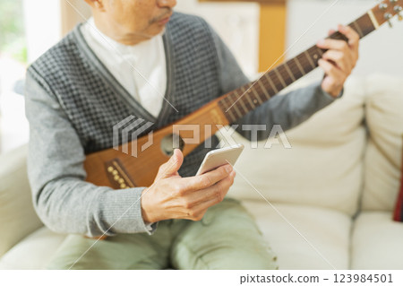 在家演奏樂器的老人 在家演奏樂器的老人 123984501