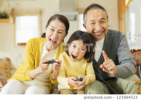 Grandparents and grandchildren enjoying a game Grandparents and grandchildren enjoying a game 123984523