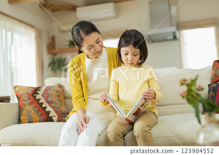 Grandmother and grandson reading a picture book 123984552