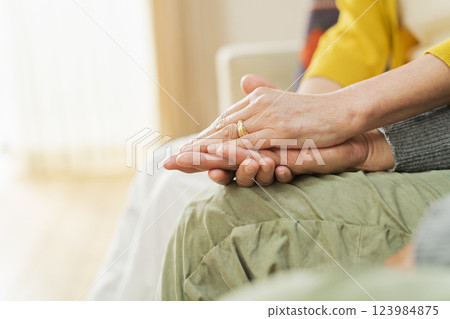 Hands of an elderly couple hugging each other 123984875