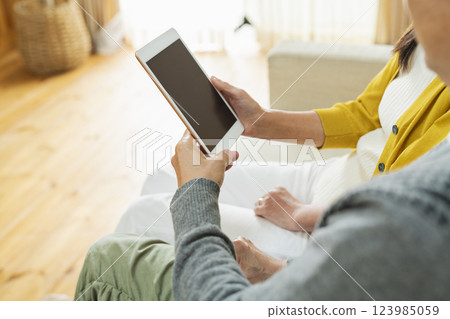一對老年夫婦在客廳使用平板電腦 123985059