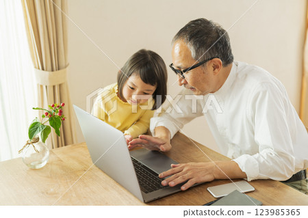 Grandfather and grandson working remotely Grandfather and grandson working remotely 123985365