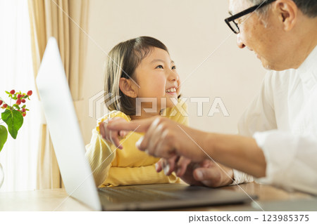 Grandfather and grandson working remotely Grandfather and grandson working remotely 123985375