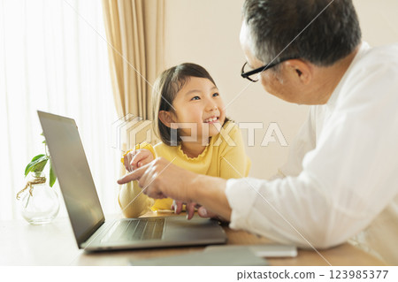 Grandfather and grandson working remotely Grandfather and grandson working remotely 123985377