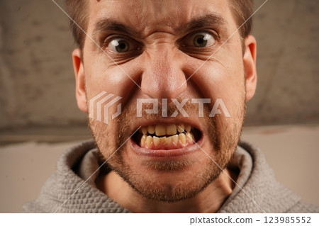 A close-up of a man's face in intense anger, his mouth wide open, showing raw emotion. His expression conveys strong frustration and fury. The image captures the power of his emotional outburst. A close-up of a man's face in intense anger, his mouth wide open, showing raw emotion. His expression conveys strong frustration and fury. The image captures the power of his emotional outburst. 123985552