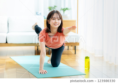 Young woman doing yoga in the living room Young woman doing yoga in the living room 123986330