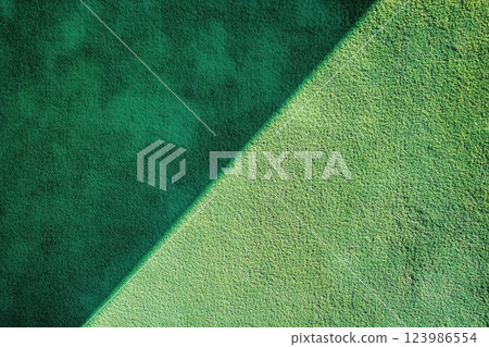 Green Textured Surface Shows Light and Shadow Contrast with Minimalist Design and Abstract Art Theme. Green Textured Surface Shows Light and Shadow Contrast with Minimalist Design and Abstract Art Theme. 123986554