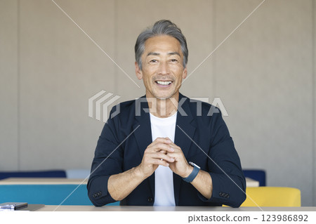 A man in his 60s smiling and looking at the camera A man in his 60s smiling and looking at the camera 123986892