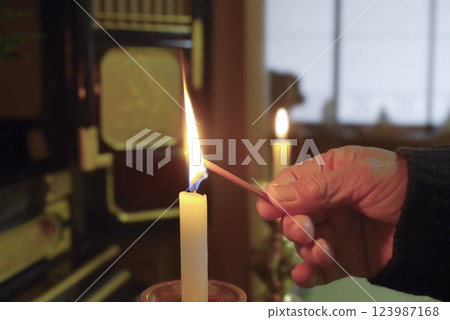 An elderly woman offering a memorial service at the Buddhist altar 123987168