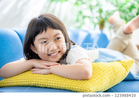 Elementary school girl lying on the sofa Elementary school girl lying on the sofa 123988410