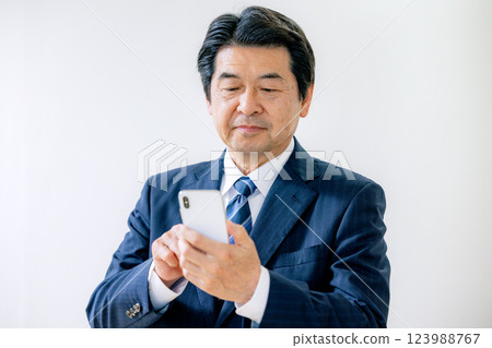 操作智慧型手機的資深商人 123988767