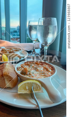 Close up of a plate with chilled jumbo shrimps in martini cocktail sauce served with two glasses of wine Close up of a plate with chilled jumbo shrimps in martini cocktail sauce served with two glasses of wine 123988807