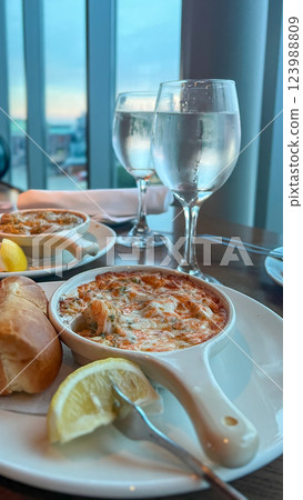 Close up of a plate with chilled jumbo shrimps in martini cocktail sauce served with two glasses of wine Close up of a plate with chilled jumbo shrimps in martini cocktail sauce served with two glasses of wine 123988809