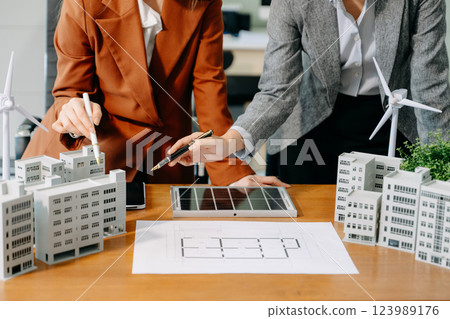 Modern office meeting of architects, designers, and developers creating innovative, sustainable housing projects Modern office meeting of architects, designers, and developers creating innovative, sustainable housing projects 123989176