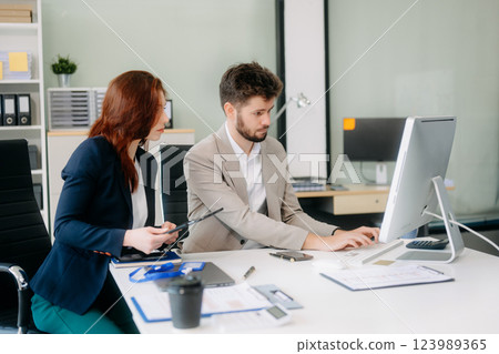 Two busy happy professional business man and woman executive leaders team using laptop working 123989365