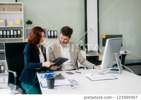 Two busy happy professional business man and woman executive leaders team using laptop working Two busy happy professional business man and woman executive leaders team using laptop working 123989367