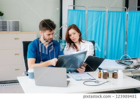 Doctors analyzing results or diagnosis of patient in clinic. Teamwork, medical and healthcare workers 123989481