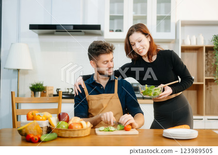 Discover a joyful couple preparing fresh vegetables, embracing healthy eating and teamwork in a vibrant kitchen Discover a joyful couple preparing fresh vegetables, embracing healthy eating and teamwork in a vibrant kitchen 123989505