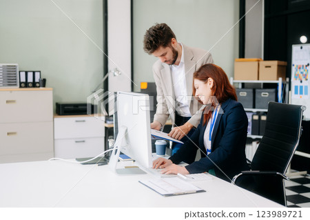 Two busy happy professional business man and woman executive leaders team using laptop working Two busy happy professional business man and woman executive leaders team using laptop working 123989721