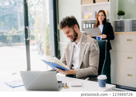 Two business workers talking on the smartphone and using laptop Two business workers talking on the smartphone and using laptop 123989726