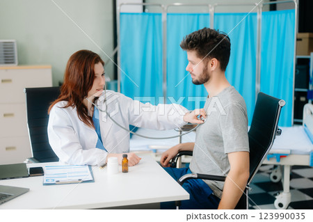Portrait of female doctor explaining diagnosis to her patient. Doctor Meeting With Patient In Exam Room 123990035