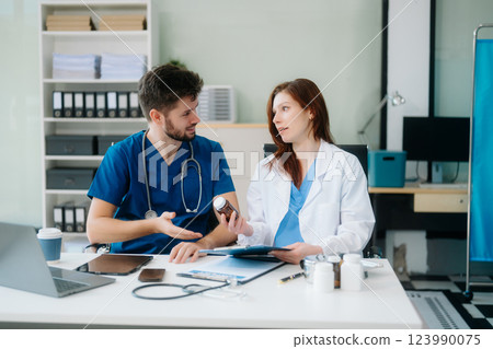 Doctors analyzing results or diagnosis of patient in clinic. Teamwork, medical and healthcare workers Doctors analyzing results or diagnosis of patient in clinic. Teamwork, medical and healthcare workers 123990075
