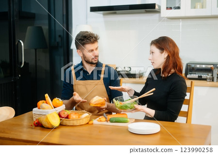 Couple cooking at home. young couple cooking together with Bread and fruit fresh vegetables, embracing healthy eating Couple cooking at home. young couple cooking together with Bread and fruit fresh vegetables, embracing healthy eating 123990258