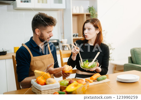 Couple cooking at home. young couple cooking together with Bread and fruit fresh vegetables, embracing healthy eating Couple cooking at home. young couple cooking together with Bread and fruit fresh vegetables, embracing healthy eating 123990259