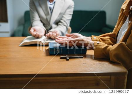 Two people reading and study bible in home and pray together.Studying the Word Of God Two people reading and study bible in home and pray together.Studying the Word Of God 123990637