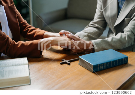 Two people reading and study bible in home and pray together.Studying the Word Of God Two people reading and study bible in home and pray together.Studying the Word Of God 123990662