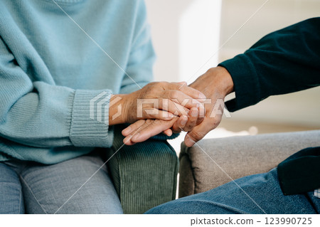 Hands of the old man and a woman hand on the table Hands of the old man and a woman hand on the table 123990725