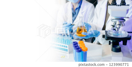 scientists in lab coats conducting research, handling glassware, and working with chemicals scientists in lab coats conducting research, handling glassware, and working with chemicals 123990771