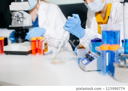 Young scientists conducting research investigations in a medical laboratory, a researcher in the foreground Young scientists conducting research investigations in a medical laboratory, a researcher in the foreground 123990774