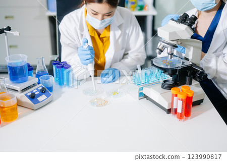 scientists in lab coats conducting research, handling glassware, and working with chemicals 123990817