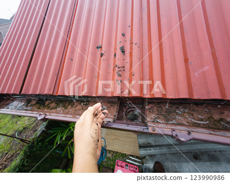 Clogged rain gutter, dirty roof gutter, with wet fallen leaves. 123990986