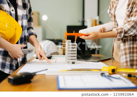 Engineer desk with object paper and tablet with blurry engineer teamwork hardworking 123991064
