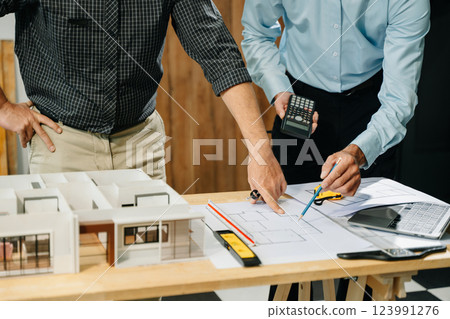 Two colleagues discussing data working and tablet, laptop with architectural project at construction site Two colleagues discussing data working and tablet, laptop with architectural project at construction site 123991276