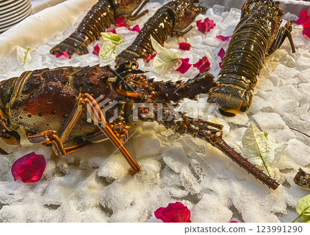 Lobster on ice with rose petals in a restaurant. Lobster on ice with rose petals in a restaurant. 123991290