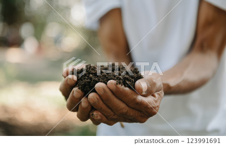 Oldman farmer holding soil in cupped hands 123991691