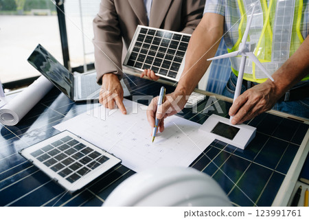 Two engineers collaborate on solar and wind energy, driving clean innovation and sustainability. A vision of teamwork 123991761