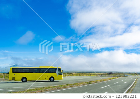Aso City, Kumamoto Prefecture - A large yellow bus parked in a parking lot in the Aso caldera heading to Daikanbo in autumn Aso City, Kumamoto Prefecture - A large yellow bus parked in a parking lot in the Aso caldera heading to Daikanbo in autumn 123992221