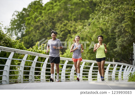 three young asian people running jogging outdoors three young asian people running jogging outdoors 123993083