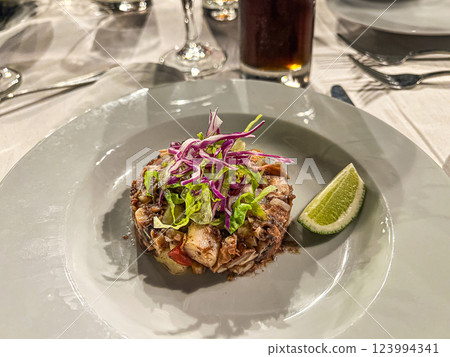Salad with meat and vegetables on a white plate in a restaurant 123994341