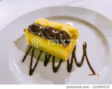 A piece of cake on a white plate with chocolate and coffee beans 123994519